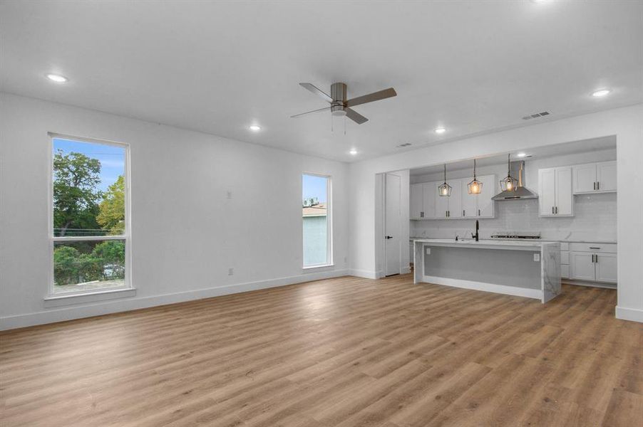 Unfurnished living room with light hardwood / wood-style floors and ceiling fan