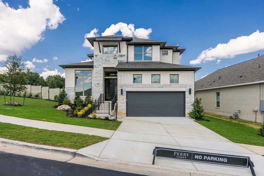 View of front of property featuring brick siding, concrete driveway, an attached garage, and stone siding View of front of property featuring brick siding, concrete driveway, an attached garage, and stone siding