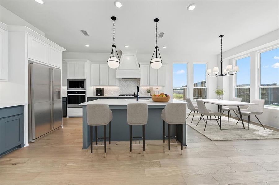 Kitchen featuring tasteful backsplash, pendant lighting, white cabinetry, built in appliances, and recessed lighting