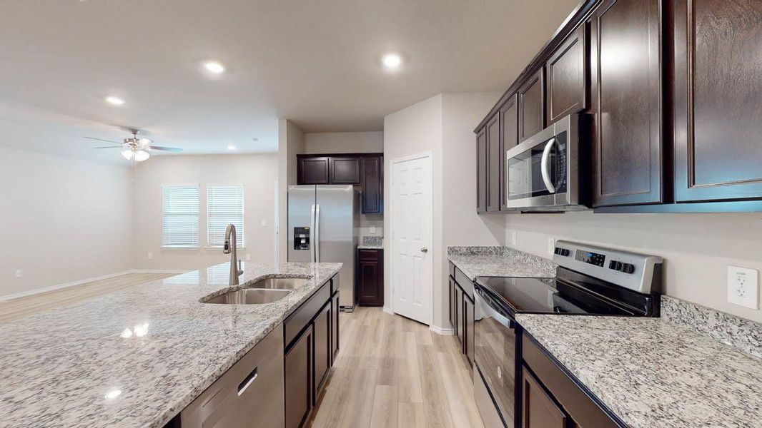 Culinary creations come alive in this kitchen, featuring an island with ample prep space and sleek appliances. Culinary creations come alive in this kitchen, featuring an island with ample prep space and sleek appliances.
