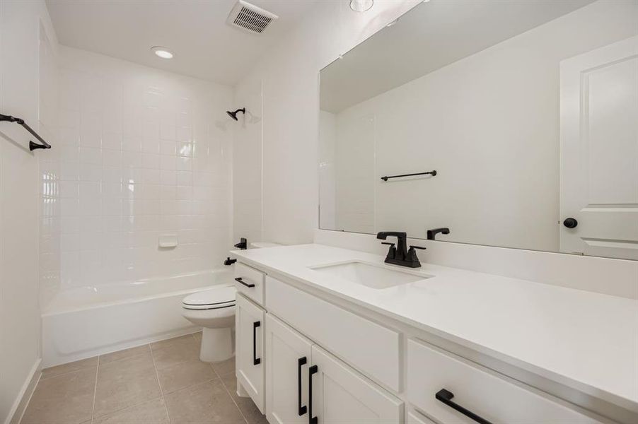 Bathroom with vanity, light tile patterned flooring, shower / bath combination, and recessed lighting Bathroom with vanity, light tile patterned flooring, shower / bath combination, and recessed lighting