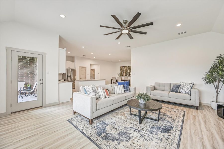 The generously sized family room opens directly to the kitchen and dining areas and features wood-look flooring, recessed lighting, a contemporary oversized ceiling fan and a full-glass door leading to the covered patio. The generously sized family room opens directly to the kitchen and dining areas and features wood-look flooring, recessed lighting, a contemporary oversized ceiling fan and a full-glass door leading to the covered patio.