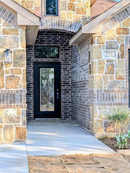 Exterior features a combination of natural stone and brickwork with an arched entryway and glass accented door, featuring a stone with address Exterior features a combination of natural stone and brickwork with an arched entryway and glass accented door, featuring a stone with address