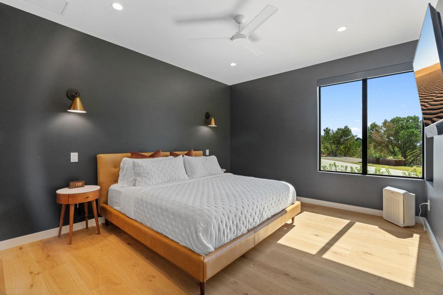 Spacious room featuring light wood-finish flooring, recessed lighting, and a modern ceiling fan