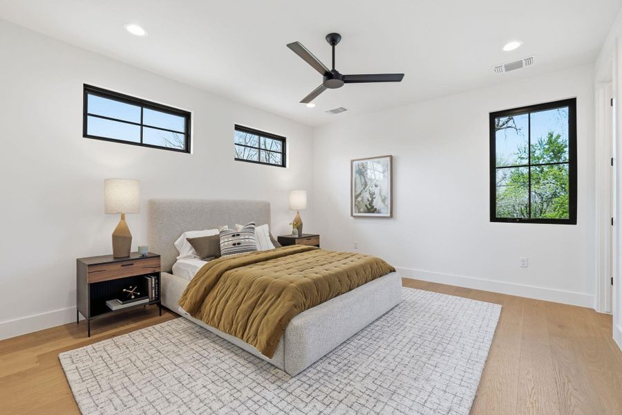 Bedroom featuring ceiling fan, light wood-style floors, recessed lighting, and multiple windows