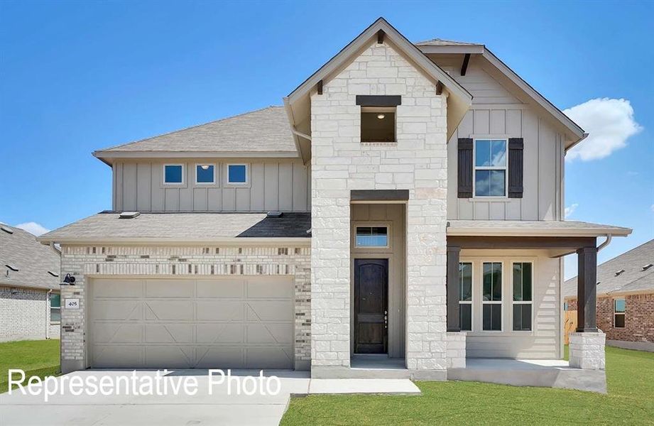 View of front of house with a front yard and a garage