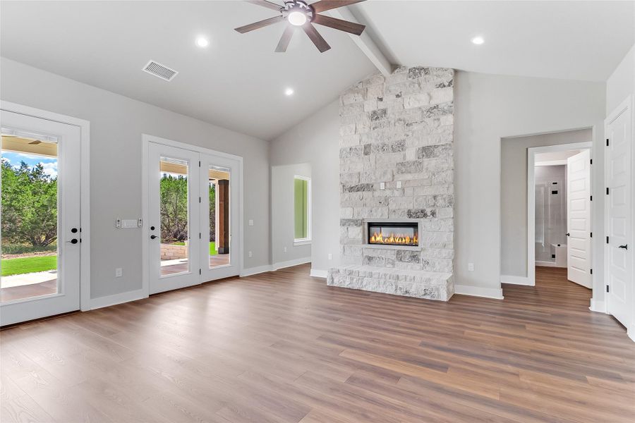 Unfurnished living room with a ceiling fan, wood finished floors, and a fireplace