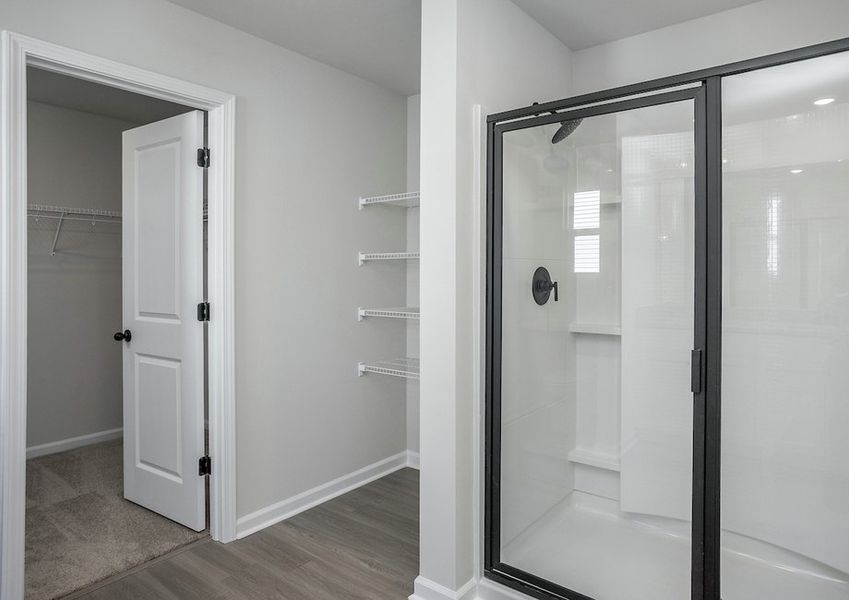 The master bathroom features a glass-enclosed shower.
