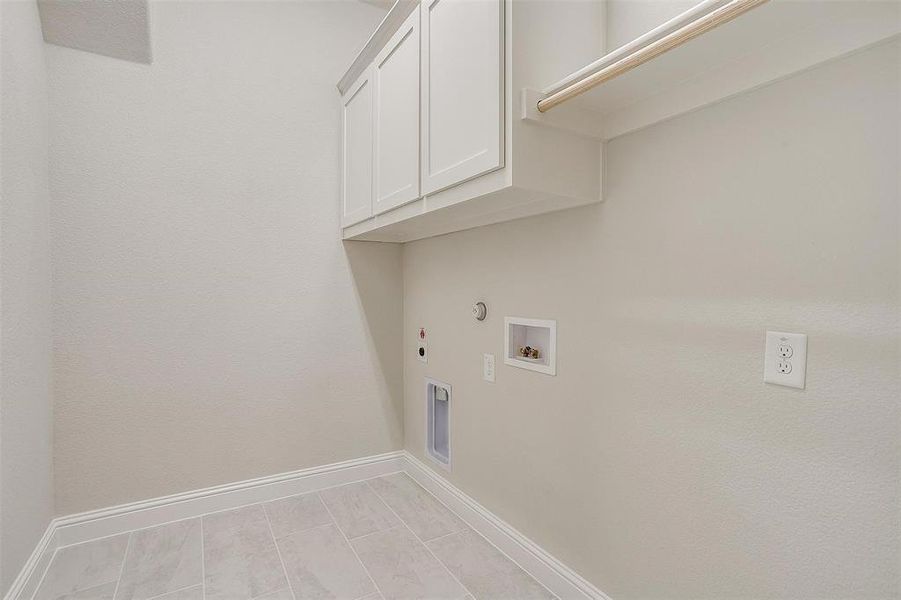 Laundry room with hookup for an electric dryer, hookup for a gas dryer, cabinets, and hookup for a washing machine