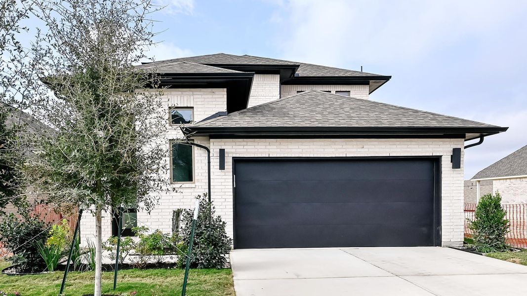 View of front facade featuring roof with shingles, brick siding, a garage, and driveway View of front facade featuring roof with shingles, brick siding, a garage, and driveway