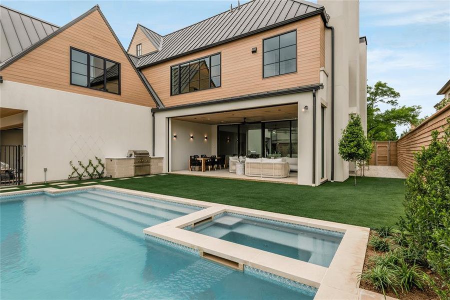 Contemporary exterior showcasing a pool, integrated spa, and an attached outdoor living space