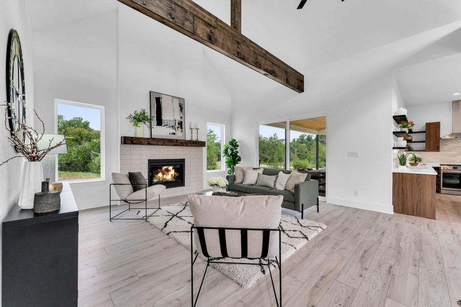 A spacious living area with vaulted ceilings and a warm fireplace opens to verdant outdoor views. A spacious living area with vaulted ceilings and a warm fireplace opens to verdant outdoor views.