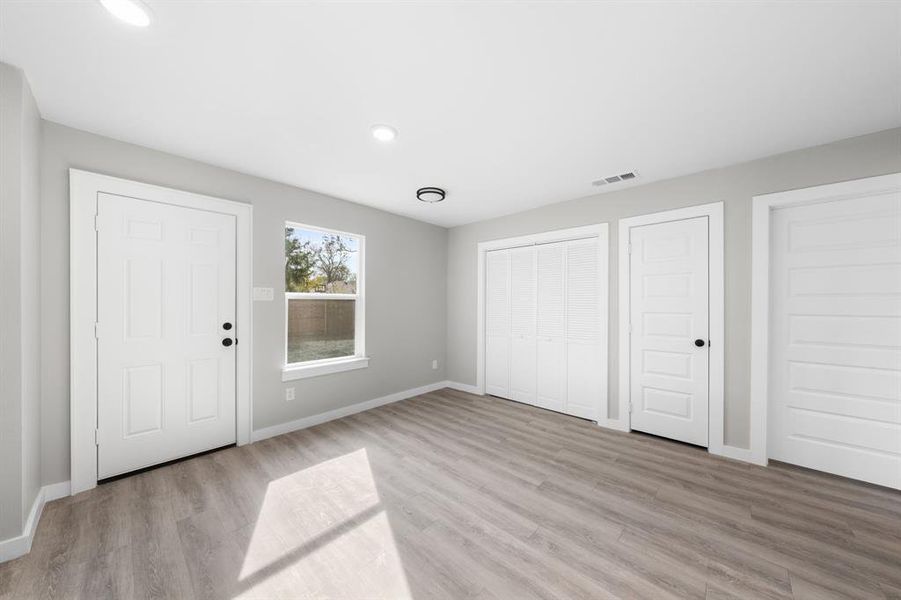 Unfurnished bedroom with light wood finished floors and recessed lighting Unfurnished bedroom with light wood finished floors and recessed lighting