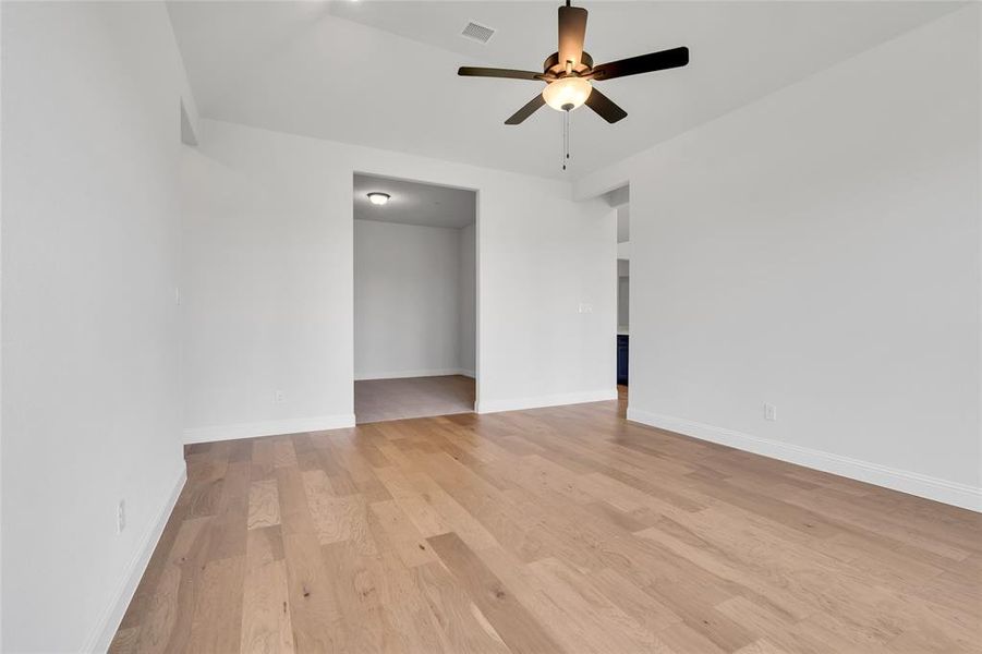 Unfurnished bedroom featuring light wood-type flooring, vaulted ceiling, and ceiling fan