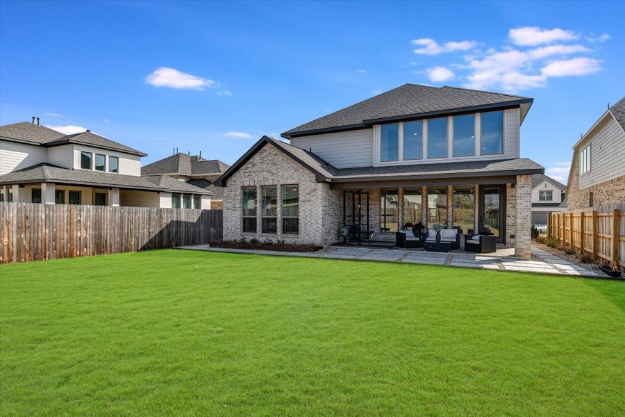 Back of property featuring a patio, brick siding, outdoor lounge area, and a fenced backyard