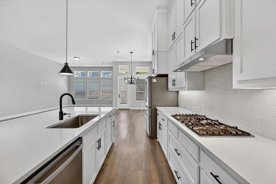 Contemporary kitchen featuring white cabinetry, quartz countertops, a gas range, and a stainless steel appliance suite Contemporary kitchen featuring white cabinetry, quartz countertops, a gas range, and a stainless steel appliance suite