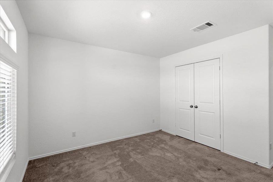 Unfurnished bedroom with dark carpet and a closet