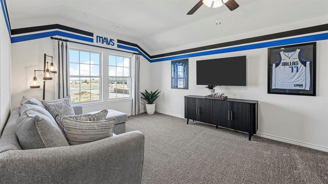 Carpeted room featuring multiple windows, a ceiling fan, and a built-in wall niche