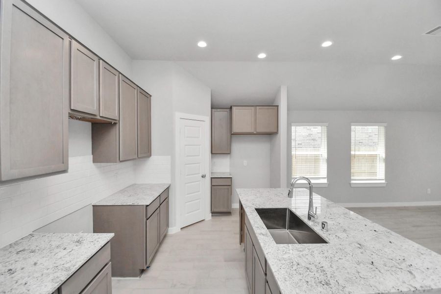 This kitchen is by far any chef’s dream! This spacious kitchen features high ceilings, stained wood cabinets, granite countertop, SS appliances, modern tile backsplash, recessed lighting, extended counter space, granite kitchen island with double sink, and space for breakfast bar, and a walk-in pantry all overlooking your huge family room.