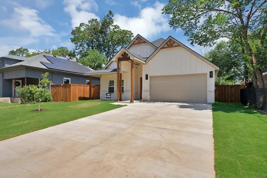 Contemporary residence featuring a two-car garage, concrete driveway, and a front yard with established landscaping Contemporary residence featuring a two-car garage, concrete driveway, and a front yard with established landscaping