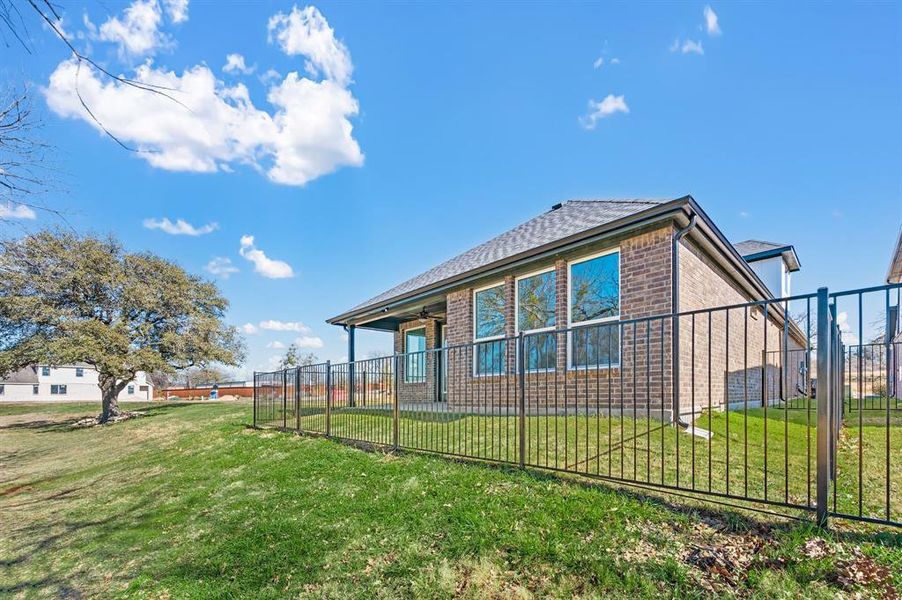 View of side of home featuring brick siding, a patio area, and roof with shingles