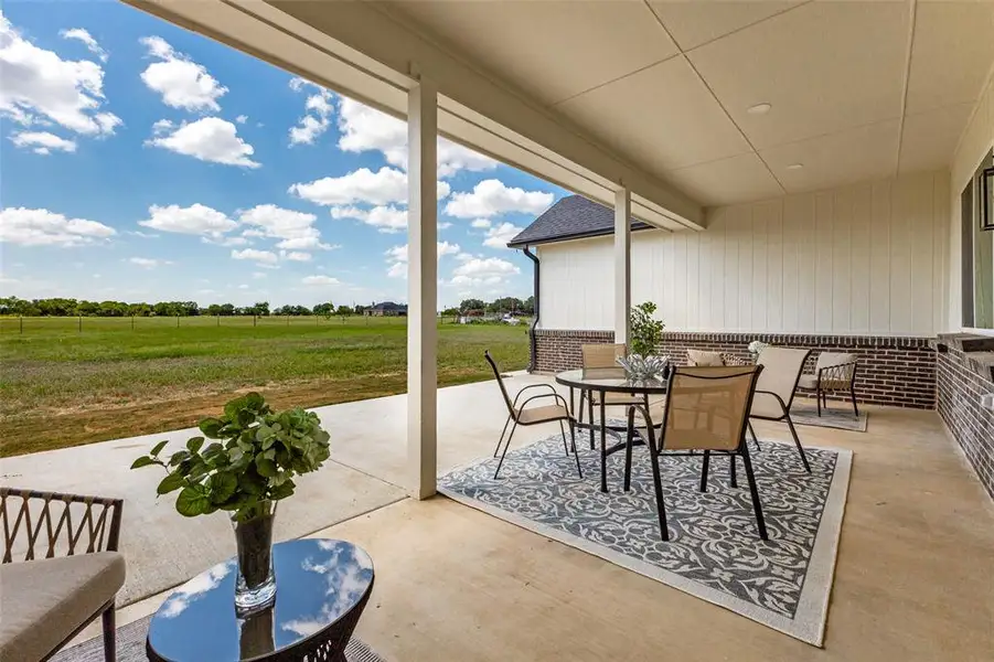 Expansive covered patio featuring a concrete slab, recessed lighting, and support columns