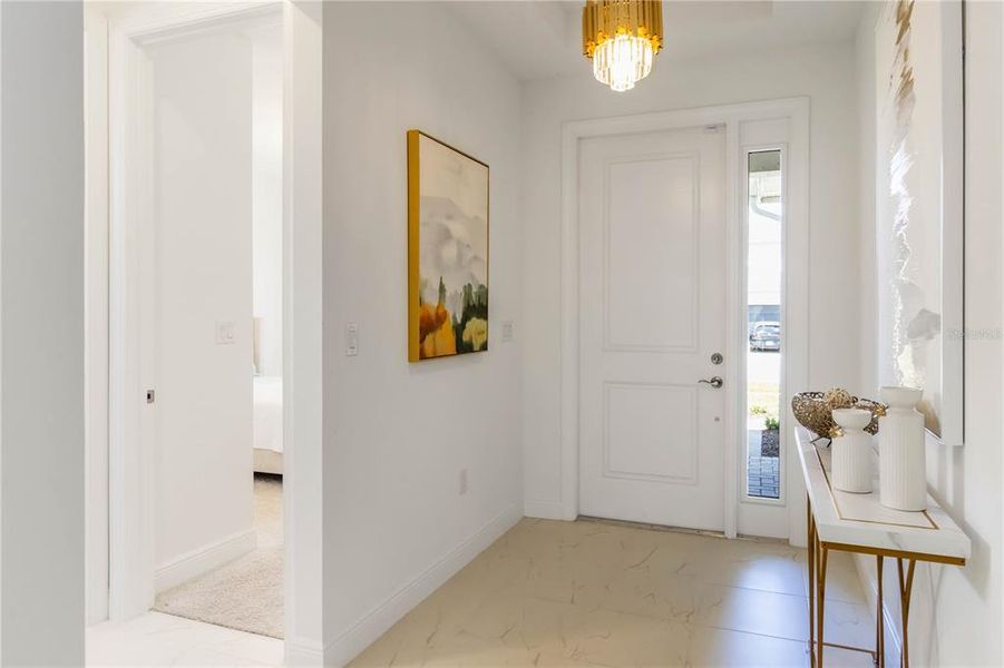 Bright Entryway with custom tile and designer light fixture