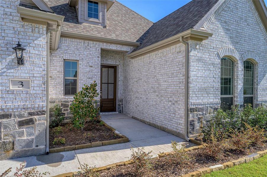 Entrance to property featuring roof with shingles and brick siding Entrance to property featuring roof with shingles and brick siding