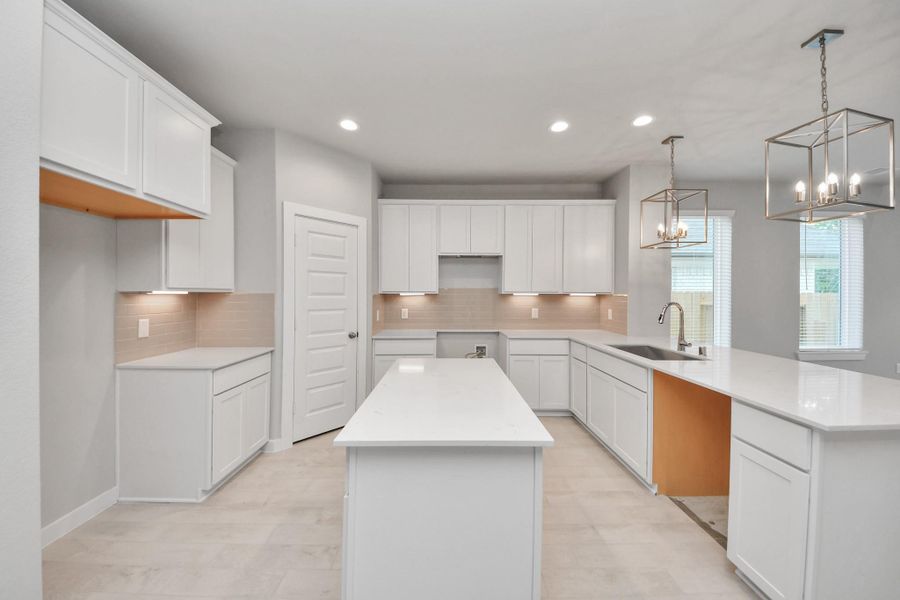 The kitchen is a culinary haven, featuring granite countertops, a tile backsplash, stainless steel appliances, 42” upper cabinets, and undercabinet lighting.