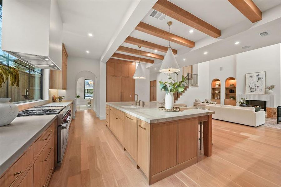 Kitchen featuring decorative light fixtures, beam ceiling, double oven range, arched walkways, and recessed lighting Kitchen featuring decorative light fixtures, beam ceiling, double oven range, arched walkways, and recessed lighting