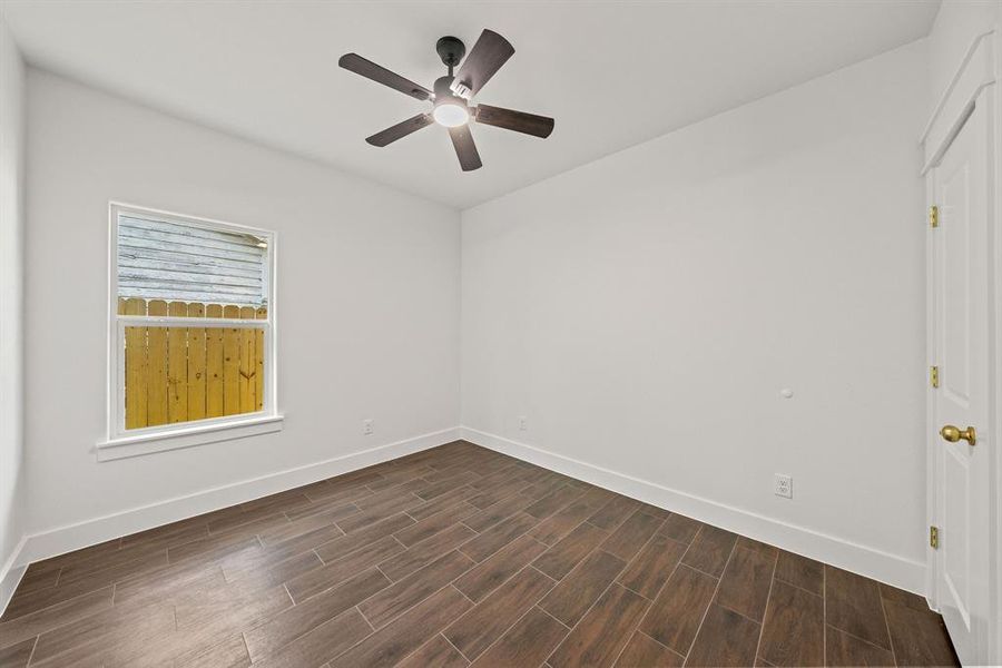 Spare room featuring wood tiled floors and ceiling fan Spare room featuring wood tiled floors and ceiling fan