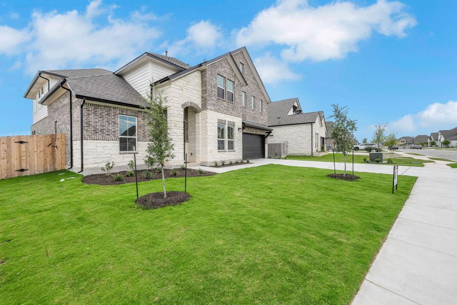 French country style house with concrete driveway, brick siding, stone siding, a shingled roof, and a residential view French country style house with concrete driveway, brick siding, stone siding, a shingled roof, and a residential view