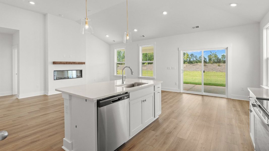 Bright open-concept kitchen and dining with quartz island and vaulted ceiling. Bright open-concept kitchen and dining with quartz island and vaulted ceiling.