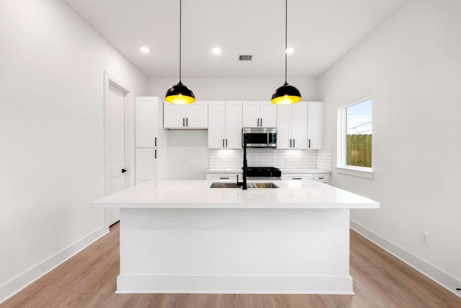 This kitchen is a chef’s dream, blending elegance with functionality! Soaring ceilings and bright white cabinetry create an open, airy feel, while stunning Quartz countertops and a sleek subway tile backsplash add a touch of modern sophistication. Stainless steel appliances, recessed lighting, and custom pendant fixtures elevate the space, making it as beautiful as it is practical. The oversized Quartz island, complete with a double sink and breakfast bar seating, is perfect for entertaining. This kitchen is a chef’s dream, blending elegance with functionality! Soaring ceilings and bright white cabinetry create an open, airy feel, while stunning Quartz countertops and a sleek subway tile backsplash add a touch of modern sophistication. Stainless steel appliances, recessed lighting, and custom pendant fixtures elevate the space, making it as beautiful as it is practical. The oversized Quartz island, complete with a double sink and breakfast bar seating, is perfect for entertaining.