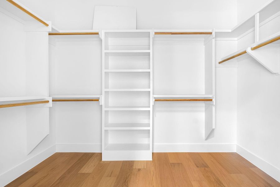 Walk in closet with hardwood / wood-style flooring Walk in closet with hardwood / wood-style flooring