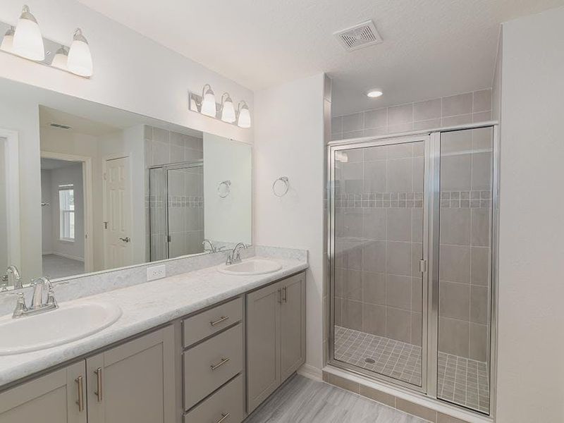 Your spacious en-suite bath includes dual vanities, a large tiled shower, and a linen closet. Your spacious en-suite bath includes dual vanities, a large tiled shower, and a linen closet.