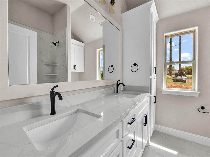 Bathroom with marble finish floor, baseboards, double vanity, and a sink Bathroom with marble finish floor, baseboards, double vanity, and a sink