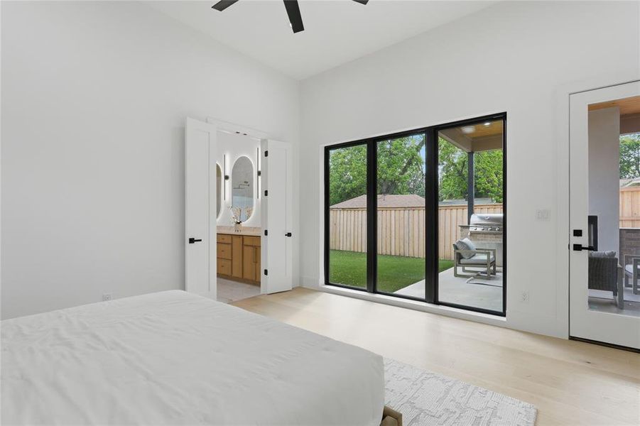 Room featuring light wood-finish flooring, a contemporary ceiling fan, and white walls Room featuring light wood-finish flooring, a contemporary ceiling fan, and white walls