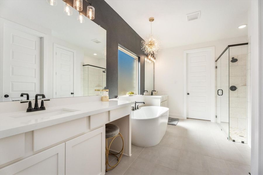 This bathroom features a modern design with a freestanding tub, a spacious glass-enclosed shower, and a double vanity with sleek black fixtures. A large window allows natural light to brighten the space, while contemporary lighting adds elegance.