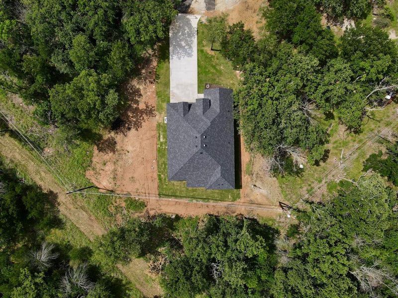 New construction home featuring a dark shingle roof and a concrete driveway