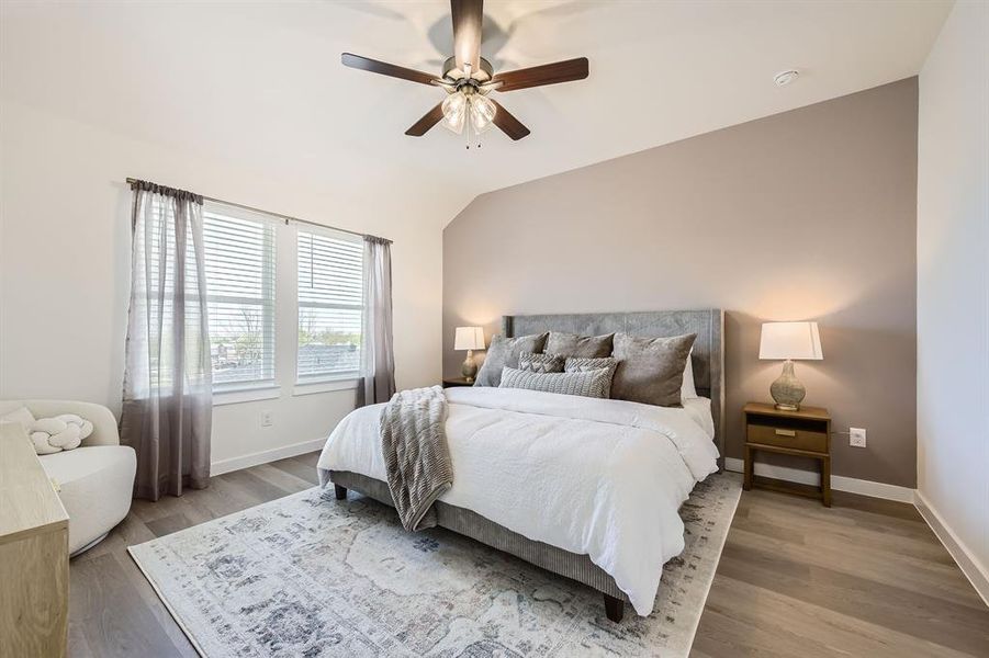 Bedroom featuring vaulted ceiling, light wood-style flooring, and ceiling fan