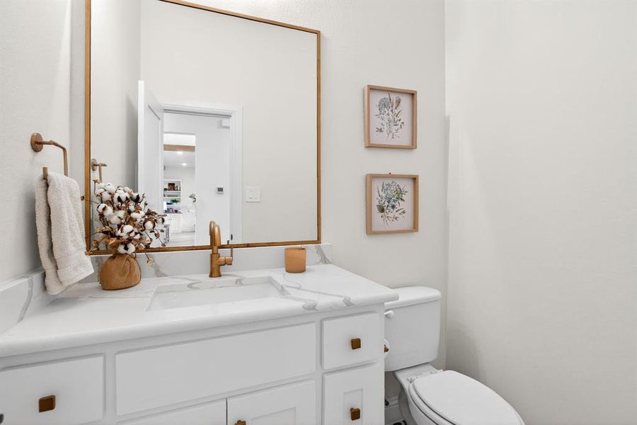Half bathroom featuring vanity and toilet Half bathroom featuring vanity and toilet