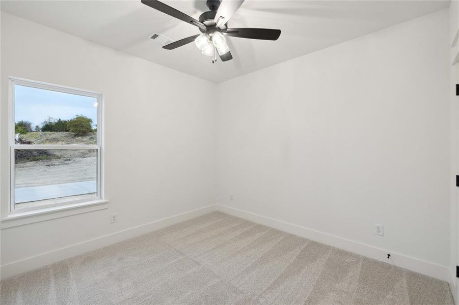 Empty room featuring carpet and ceiling fan