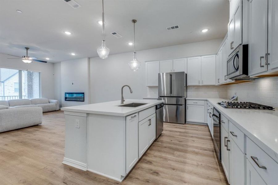 Kitchen featuring a sink, visible vents, appliances with stainless steel finishes, and light wood finished floors