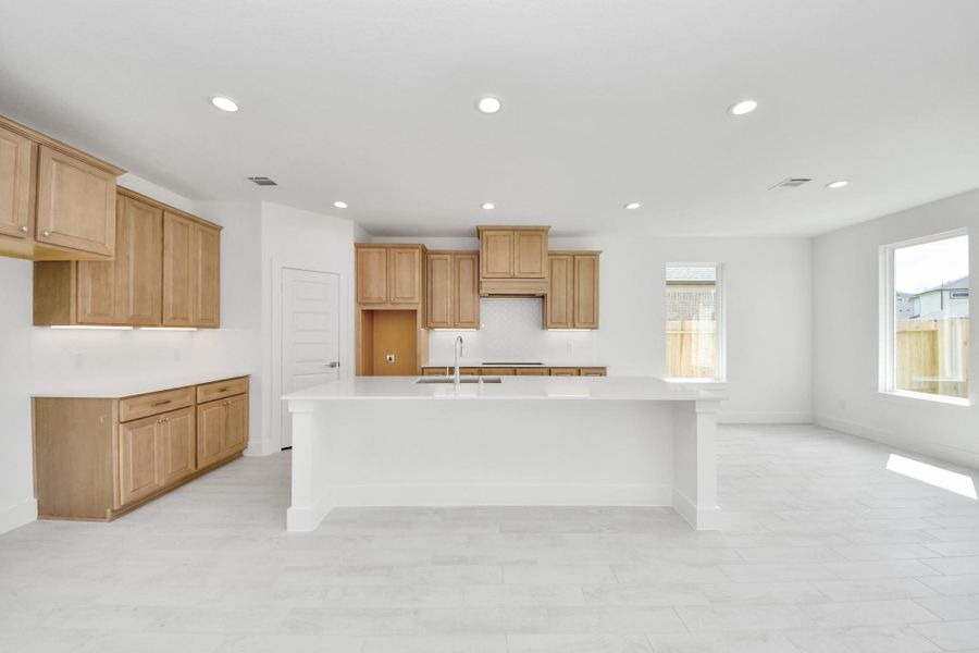 This generously spacious kitchen is a dream realized! With a massive granite island, high ceilings, soft close cabinets, granite countertops, stainless steel appliances, a sleek tile backsplash, recessed lighting, and an extended counter area, it offers both style and practicality. All this opens up to the expansive family room, creating a perfect hub for gatherings. This generously spacious kitchen is a dream realized! With a massive granite island, high ceilings, soft close cabinets, granite countertops, stainless steel appliances, a sleek tile backsplash, recessed lighting, and an extended counter area, it offers both style and practicality. All this opens up to the expansive family room, creating a perfect hub for gatherings.