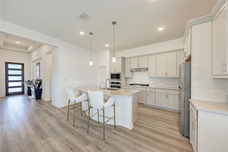 Modern kitchen with an inviting island and elegant flooring, perfect for entertaining.