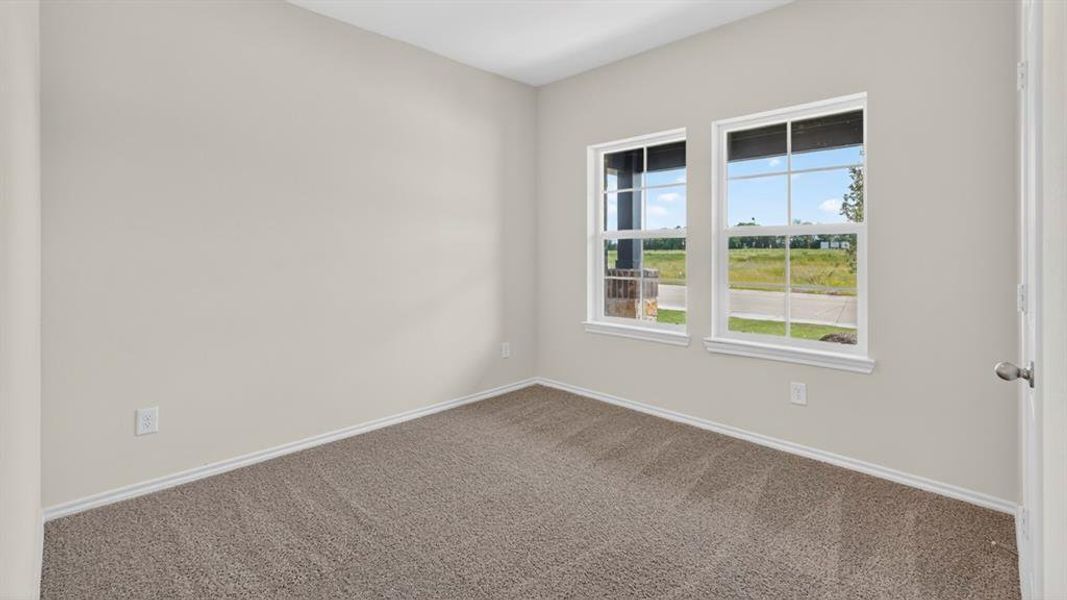 Room featuring two large windows with white frames, neutral-toned carpeting, light gray wall paint, and white baseboards