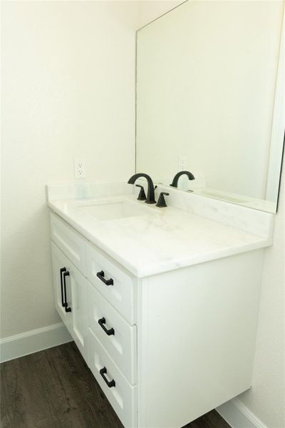 Bathroom featuring vanity and dark wood-type flooring