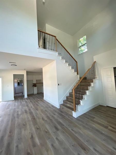 Stairs with wood-type flooring and a high ceiling