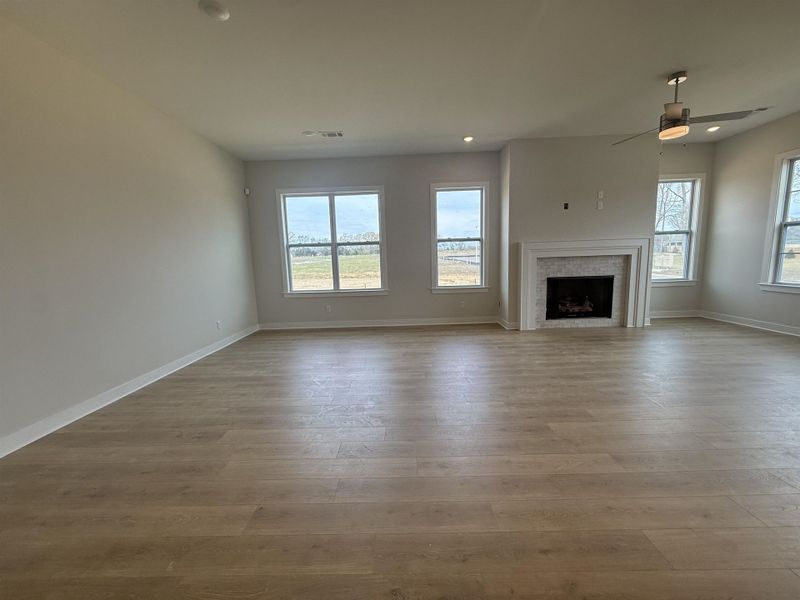 Unfurnished living room with a fireplace, ceiling fan, plenty of natural light, light wood-style floors, and recessed lighting